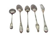 five silver spoons and a fork are lined up on a white surface