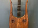 an old wooden instrument sitting on top of a table next to a wall