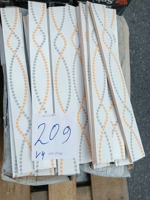 Plusieurs morceaux de bois sont empilés sur une palette, accompagnés d'une étiquette de prix