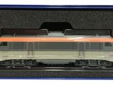 une maquette de train dans une boîte, posée sur une surface blanche
