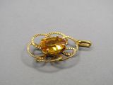 un gros plan d'un pendentif plaqué or orné d'une citrine