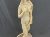 statue d'une femme tenant une fleur à la main