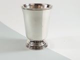 a silver cup sitting on top of a white table