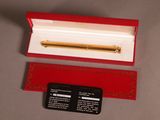 une boîte rouge contenant un stylo doré