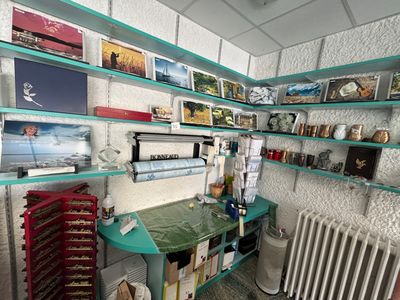 une pièce avec une table, un radiateur et des tableaux accrochés au mur