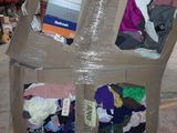 a cardboard box that has a bunch of clothes inside of it