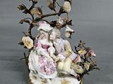 a figurine of a man and a woman sitting on a tree