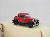 a red toy car sitting on top of a cardboard box