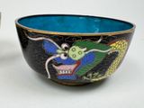 two bowls with designs on them sitting next to each other