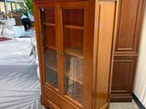a wooden cabinet with a glass door in a room