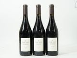 trois bouteilles de vin posées sur une table blanche