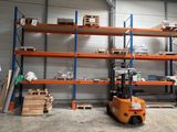 a forklift in a warehouse with lots of pallets