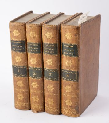 three old books sitting on top of each other on a white surface