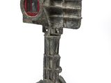 a small metal object with a red light on top of it