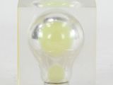 a small light bulb in a clear box on a white surface