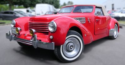 une voiture de collection rouge garée sur le bord de la route