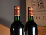 two bottles of wine sitting on a table next to each other