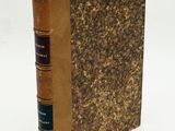 an old book sitting on top of a table next to a white background