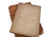 three old books stacked on top of each other on a white surface