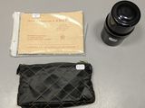 une image représentant un appareil photo et un portefeuille posés sur une table