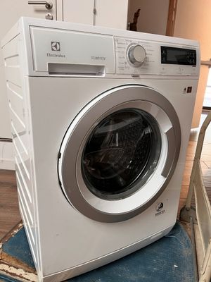 a washing machine sitting on top of a chair in a kitchen