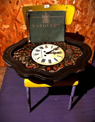une petite table sur laquelle se trouvent une horloge et un livre