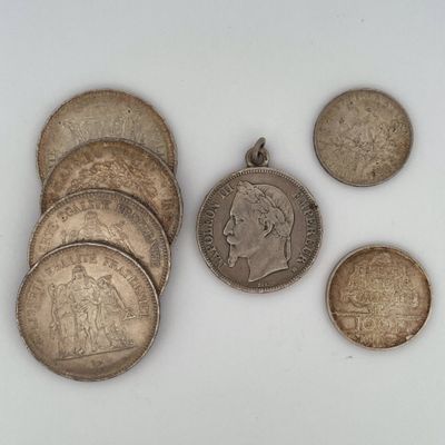 plusieurs pièces de monnaie de tailles et de formes différentes posées sur une surface blanche