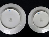 two white plates with blue dots on them on a black surface