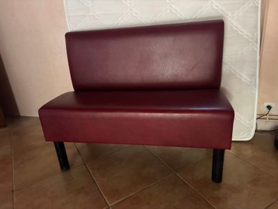banquette en cuir bordeaux avec des pieds noirs