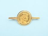 a close up of a gold ring with a coin on it