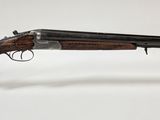 un fusil avec un canon en bois et un socle en acrylique transparent