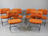 six orange chairs with chrome legs and a cushion on them