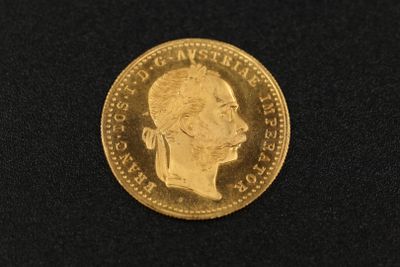 a close up of a gold coin on a black surface