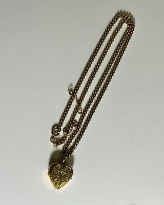 a necklace with a heart on it sitting on a table