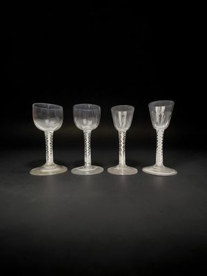 quatre verres sont alignés sur une surface noire