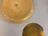 three pieces of pottery sitting on a table with a white cloth