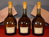 three bottles of wine sitting on a red table with a wooden box in the background