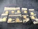 several gold coins in plastic bags sitting on a black surface