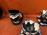 une tasse et une soucoupe noires et blanches posées sur une table
