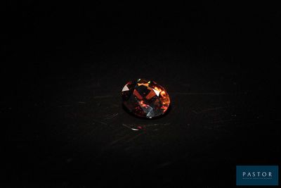 un diamant orange sur une surface noire