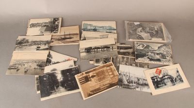 plusieurs vieilles photos en noir et blanc représentant des personnes et des véhicules, posées sur une table