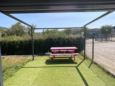 une table de pique-nique rouge posée au milieu d'une pelouse