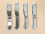 trois couteaux et une fourchette sont posés les uns à côté des autres sur une table