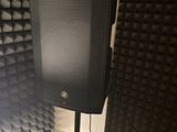 a speaker that is sitting on a stand in front of a wall