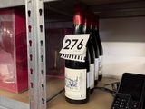 bottles of wine on a shelf in a store with price tags on them