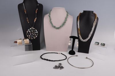 Plusieurs colliers et bracelets sont exposés sur une table