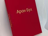 an open red book sitting on top of a chair next to a white chair