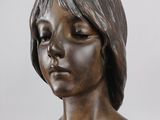 bronze bust of a woman with a cross on her chest