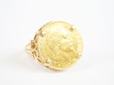 l'image d'une bague en or sur laquelle se trouve une pièce de monnaie