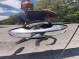 a reflection of a man taking a picture of himself in the mirror of a car